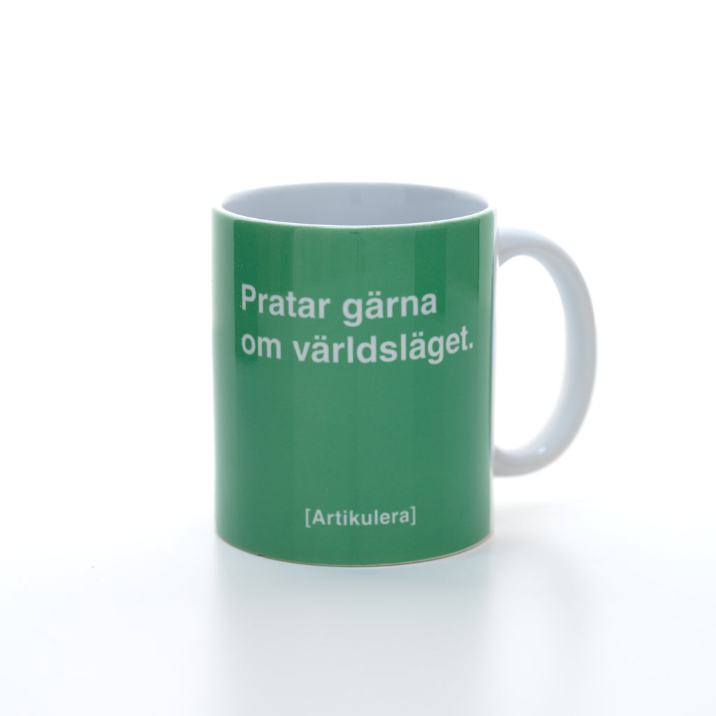 Vit mugg med klargrönt tryck, vit text ”Pratar gärna om världsläget.” samt vit Artikulera-logotyp