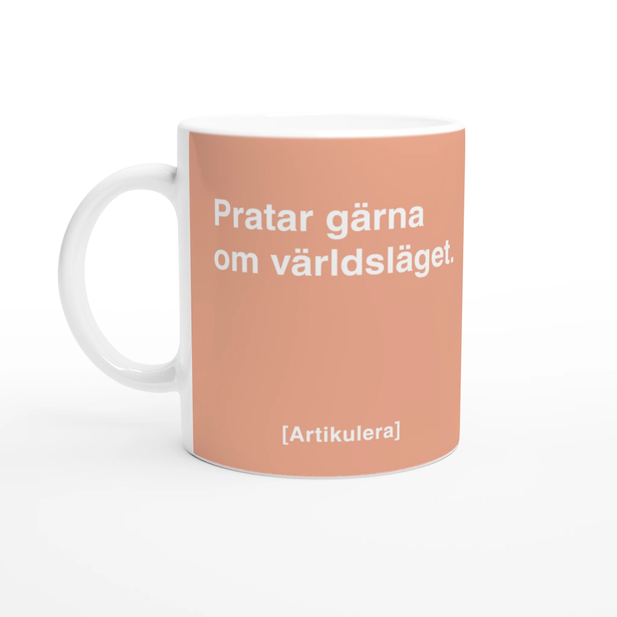 Vit mugg med persikofärgat tryck, vit text ”Pratar gärna om världsläget.” samt vit Artikulera-logotyp