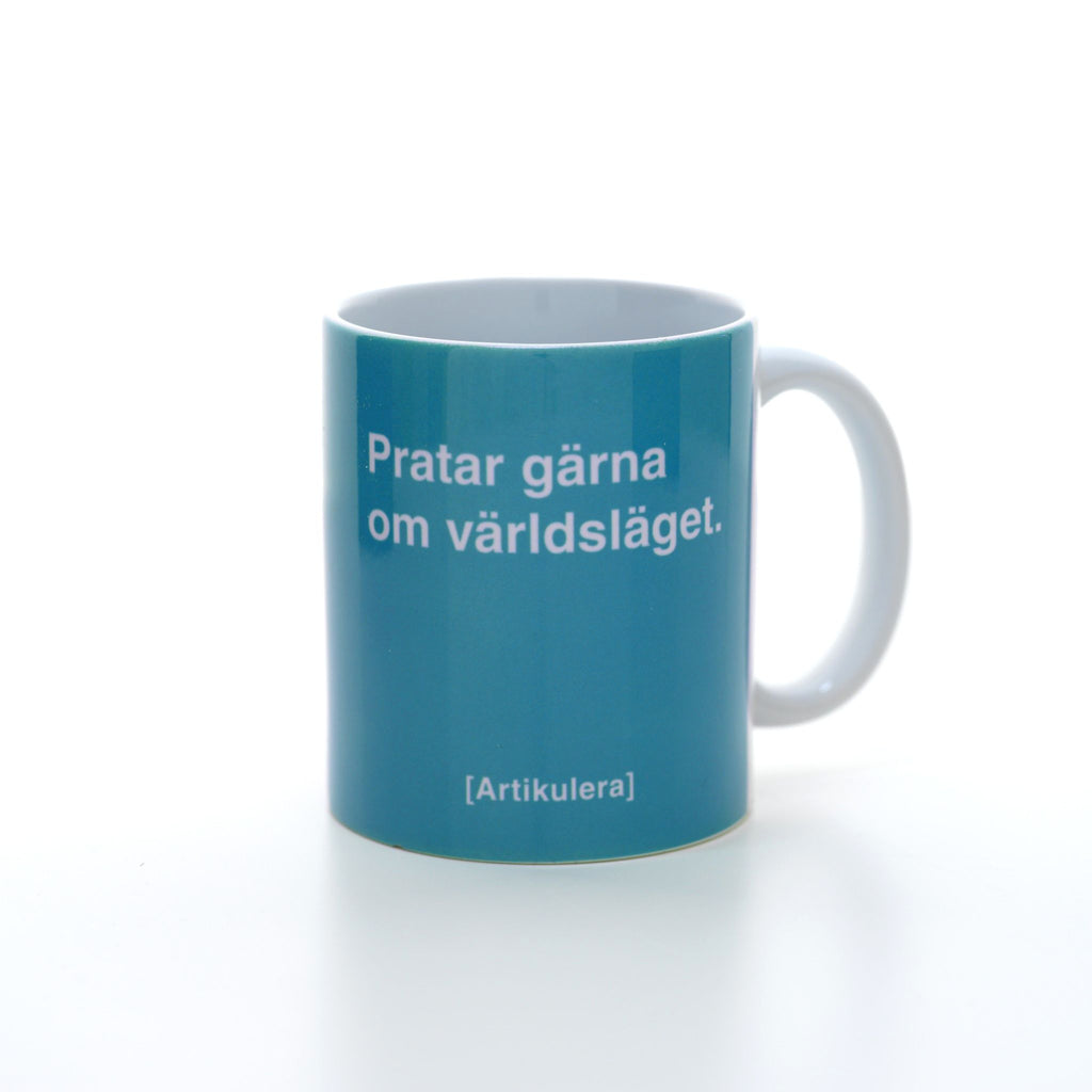 Vit mugg med mörkt turkos, vit text ”Pratar gärna om världsläget.” samt vit Artikulera-logotyp