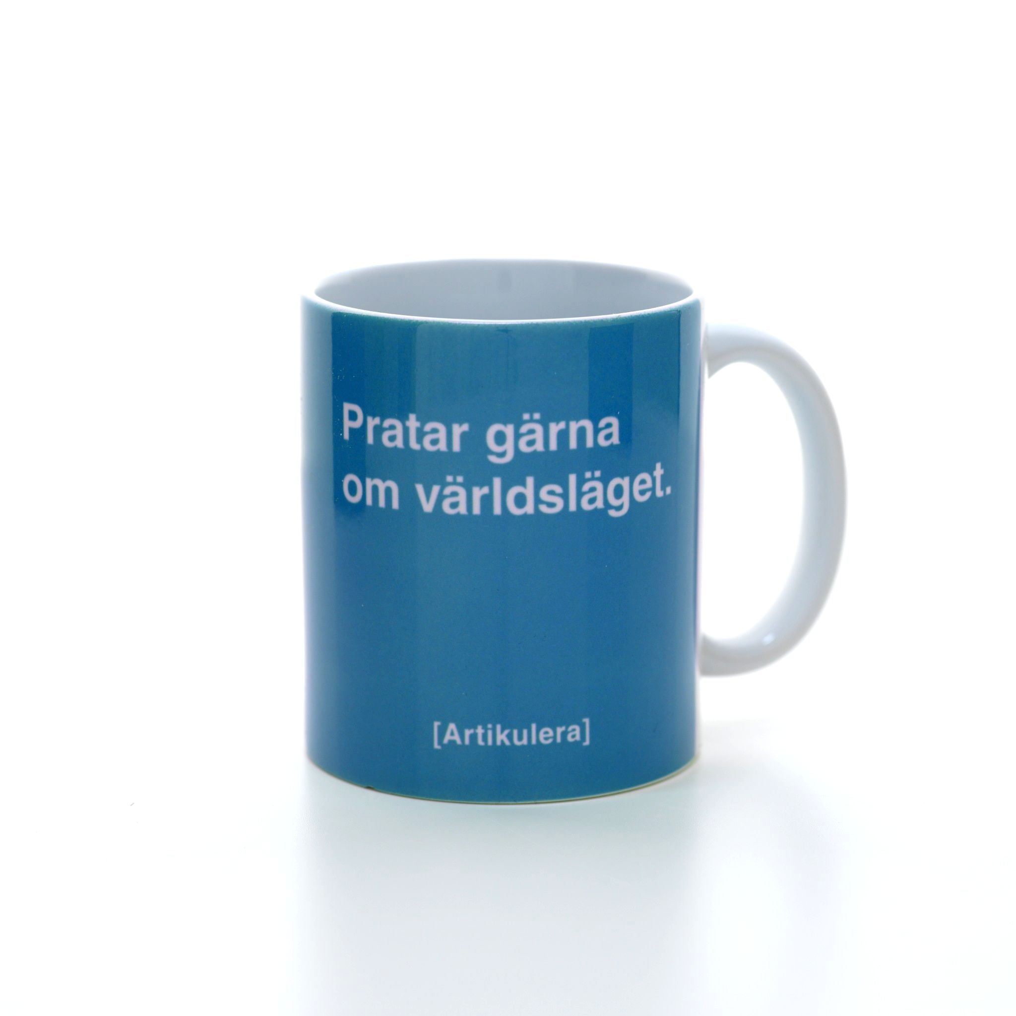 Vit mugg med himmelsblått tryck, vit text ”Pratar gärna om världsläget.” samt vit Artikulera-logotyp