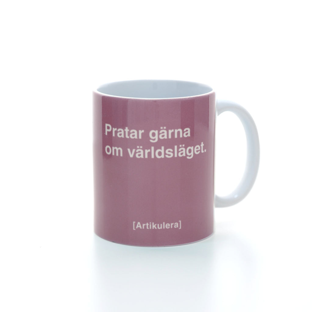 Vit mugg med ljusrosa tryck, vit text ”Pratar gärna om världsläget.” samt vit Artikulera-logotyp