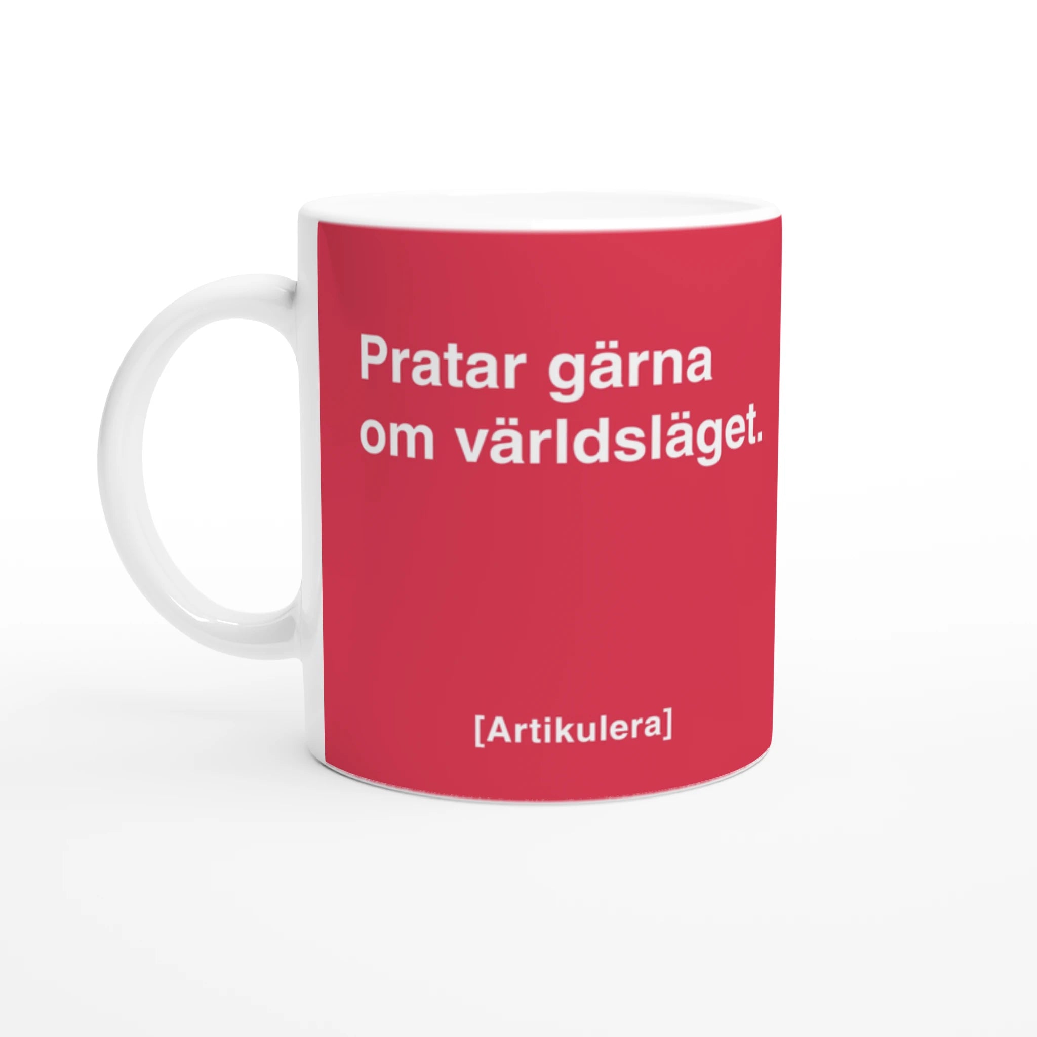 Vit mugg med magentarött tryck, vit text ”Pratar gärna om världsläget.” samt vit Artikulera-logotyp