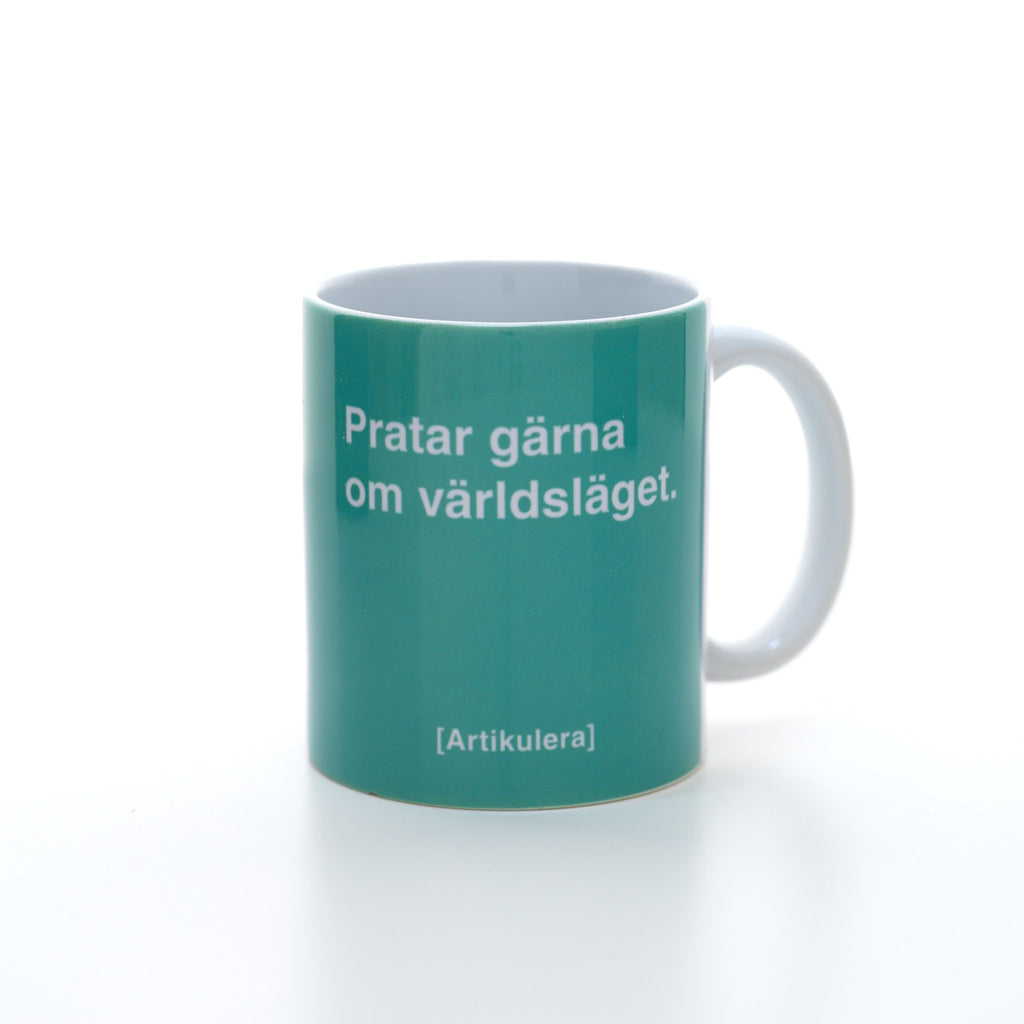 Vit mugg med mintgrönt tryck, vit text ”Pratar gärna om världsläget.” samt vit Artikulera-logotyp