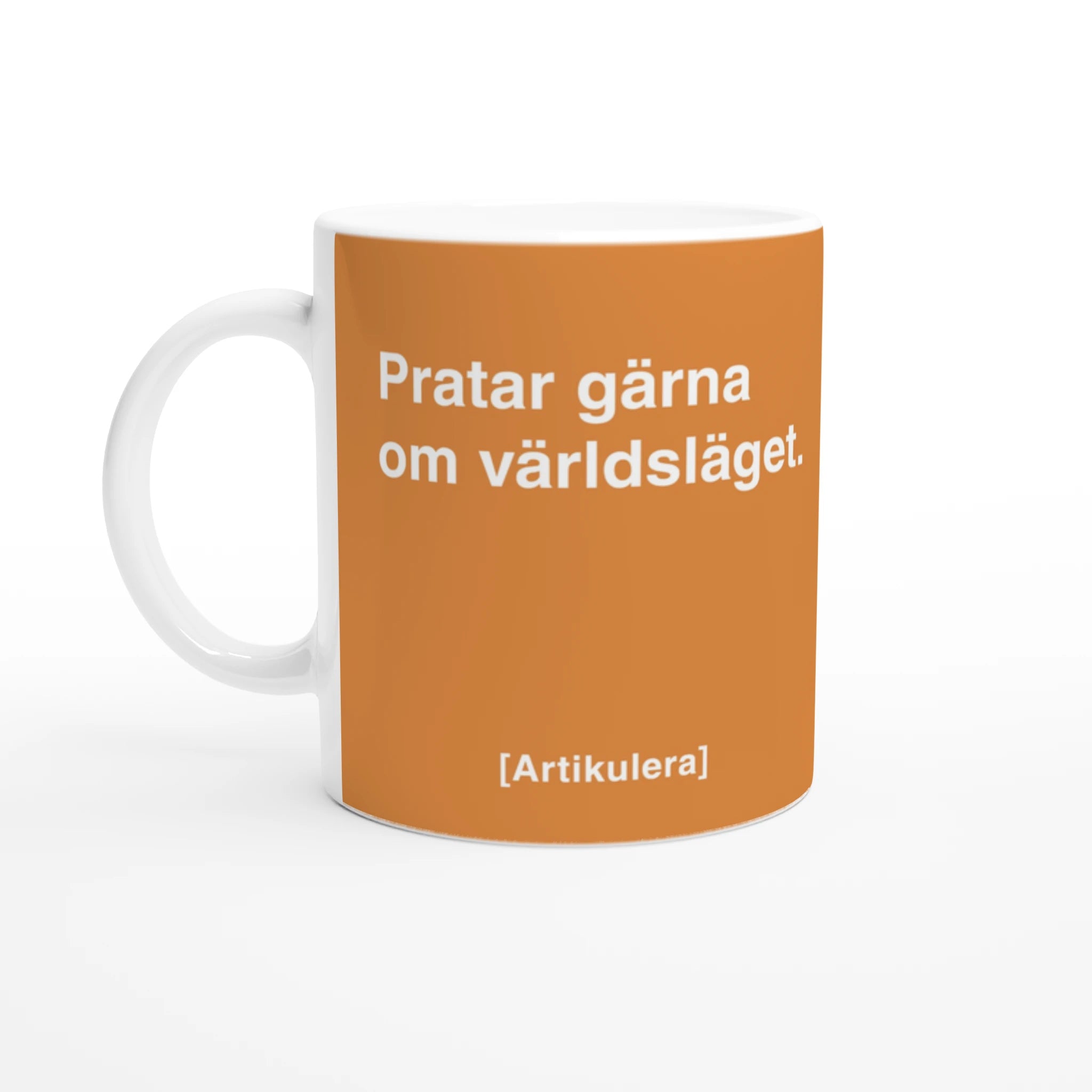 Vit mugg med orange tryck, vit text ”Pratar gärna om världsläget.” samt vit Artikulera-logotyp