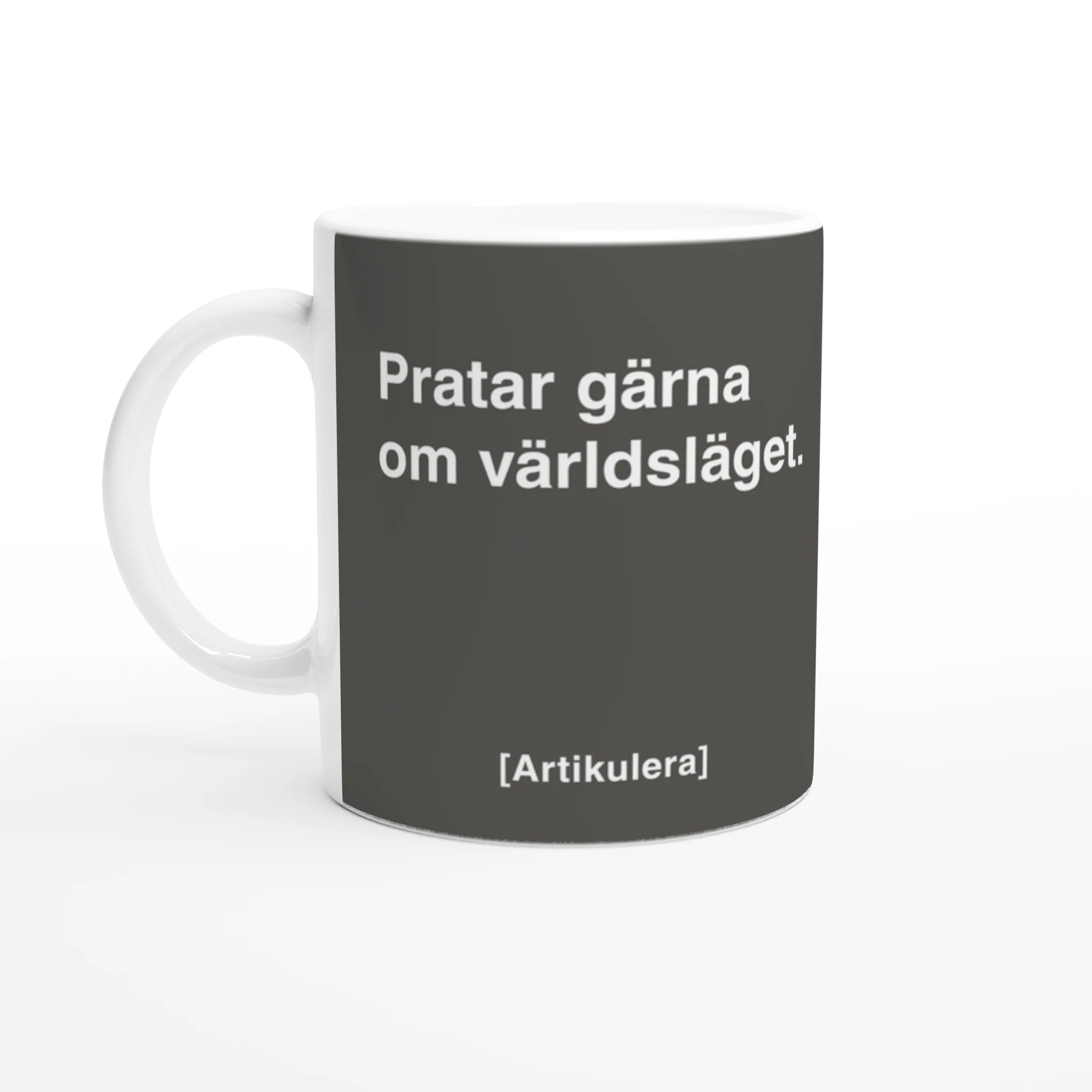 Vit mugg med rockigt grått tryck, vit text ”Pratar gärna om världsläget.” samt vit Artikulera-logotyp