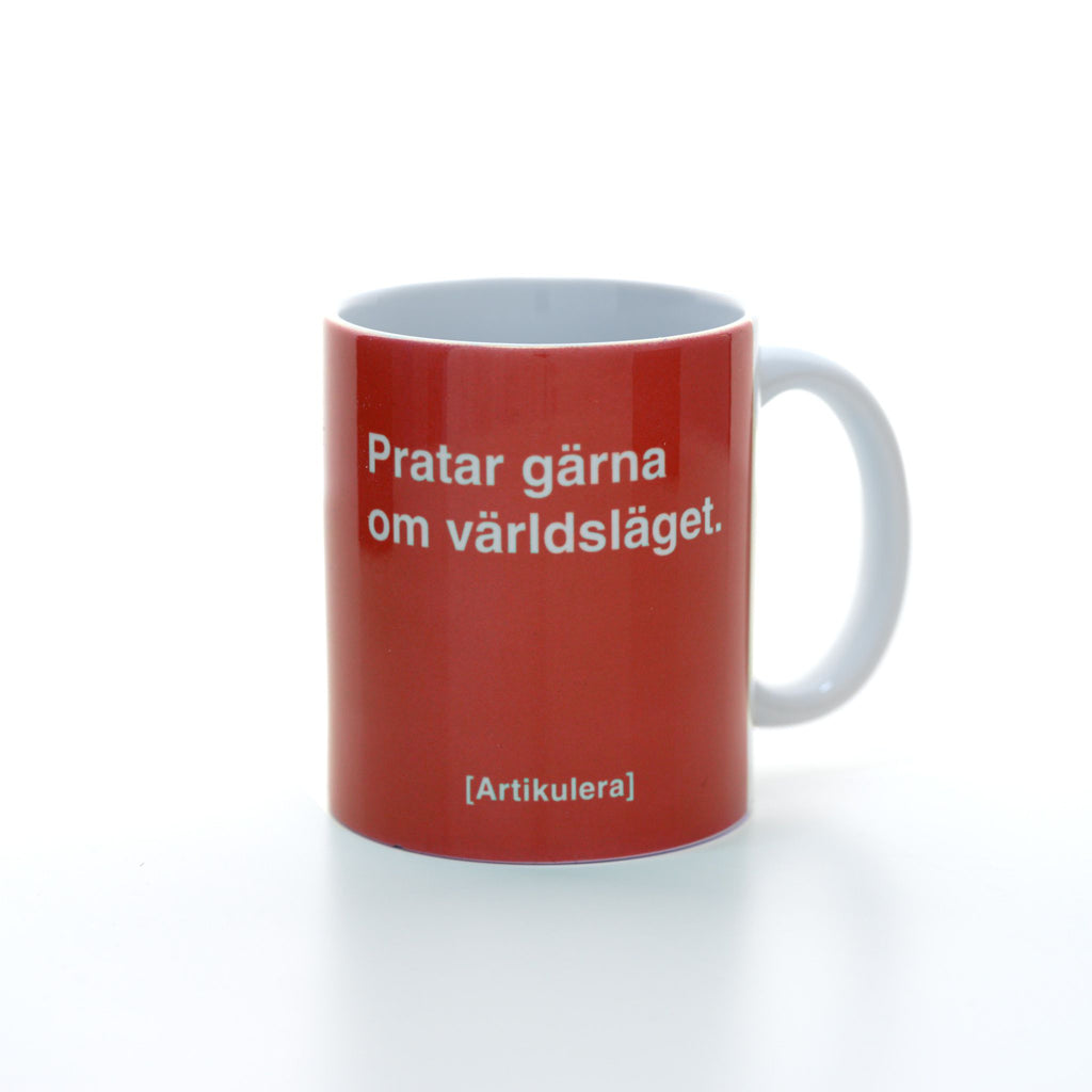Vit mugg med tomatrött tryck, vit text ”Pratar gärna om världsläget.” samt vit Artikulera-logotyp