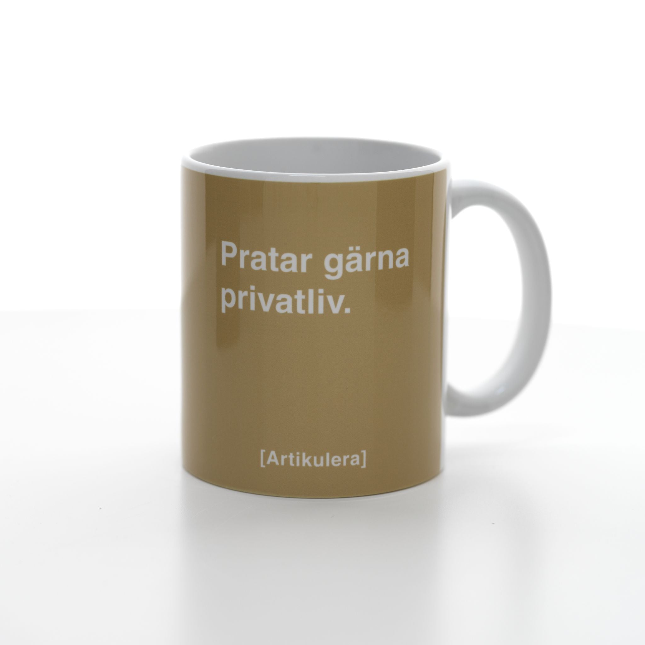 Vit mugg med beige tryck, vit text ”Pratar gärna privatliv.” samt vit Artikulera-logotyp
