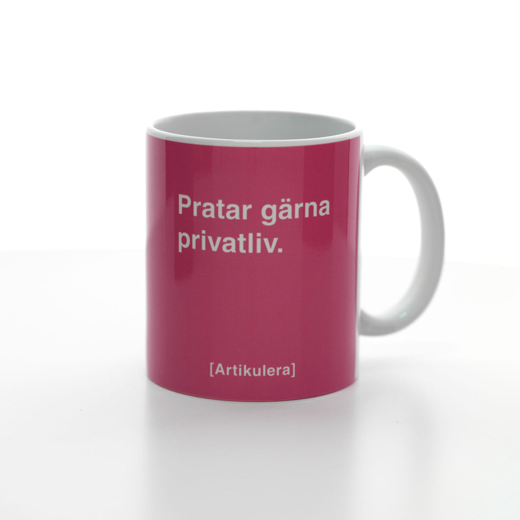 Vit mugg med cerise tryck, vit text ”Pratar gärna privatliv.” samt vit Artikulera-logotyp