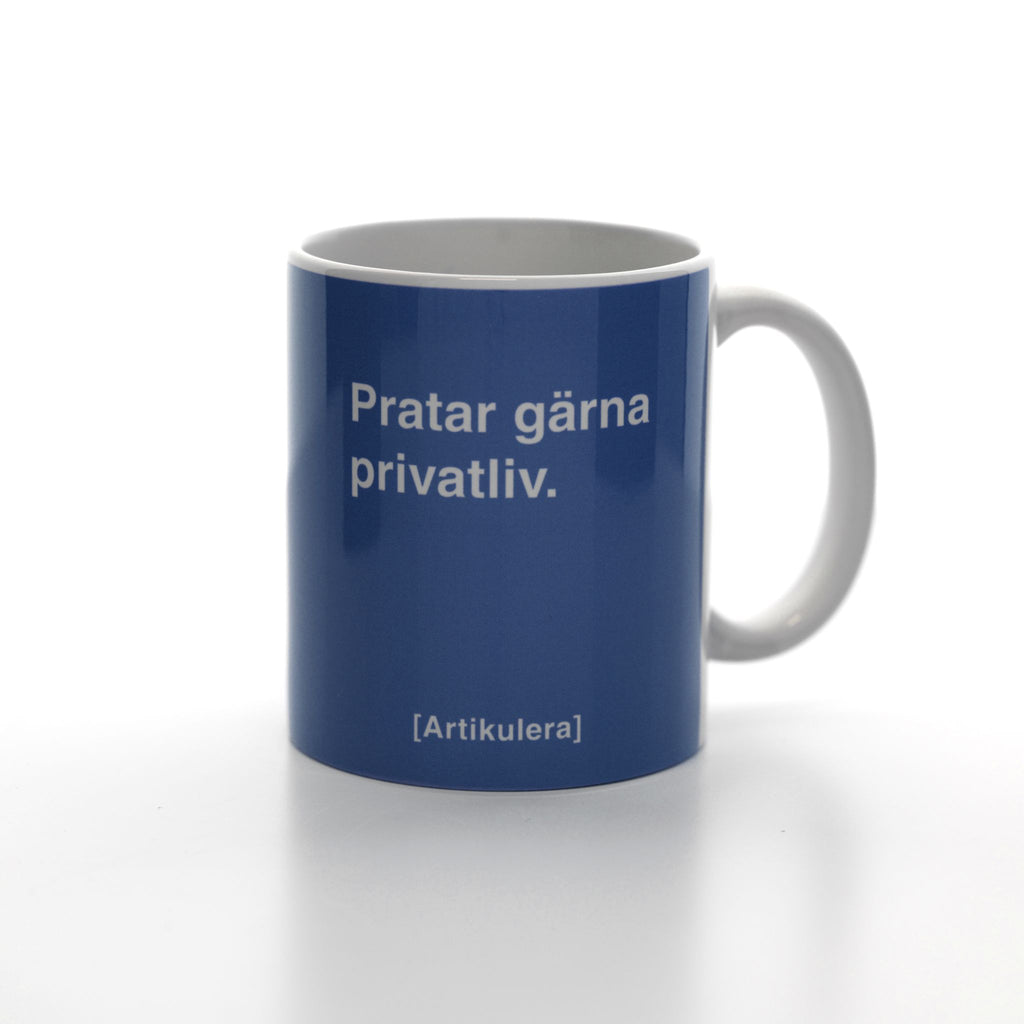 Vit mugg med duvblått tryck, vit text ”Pratar gärna privatliv.” samt vit Artikulera-logotyp