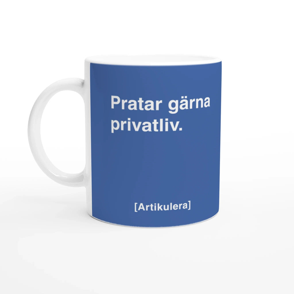 Vit mugg med duvblått tryck, vit text ”Pratar gärna privatliv.” samt vit Artikulera-logotyp