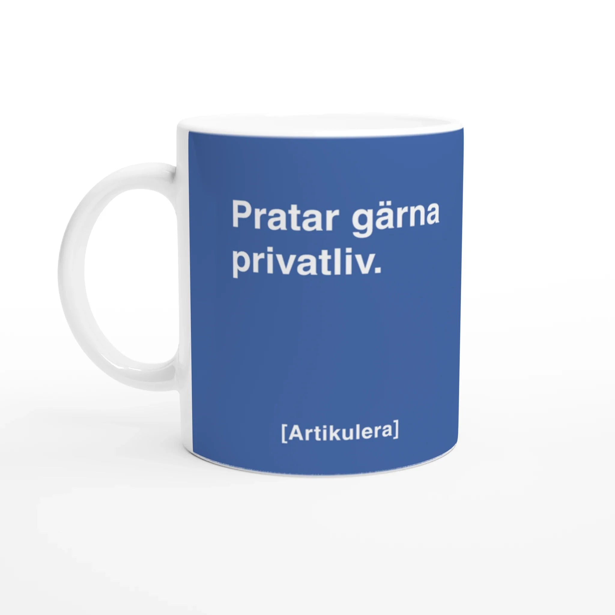 Vit mugg med duvblått tryck, vit text ”Pratar gärna privatliv.” samt vit Artikulera-logotyp