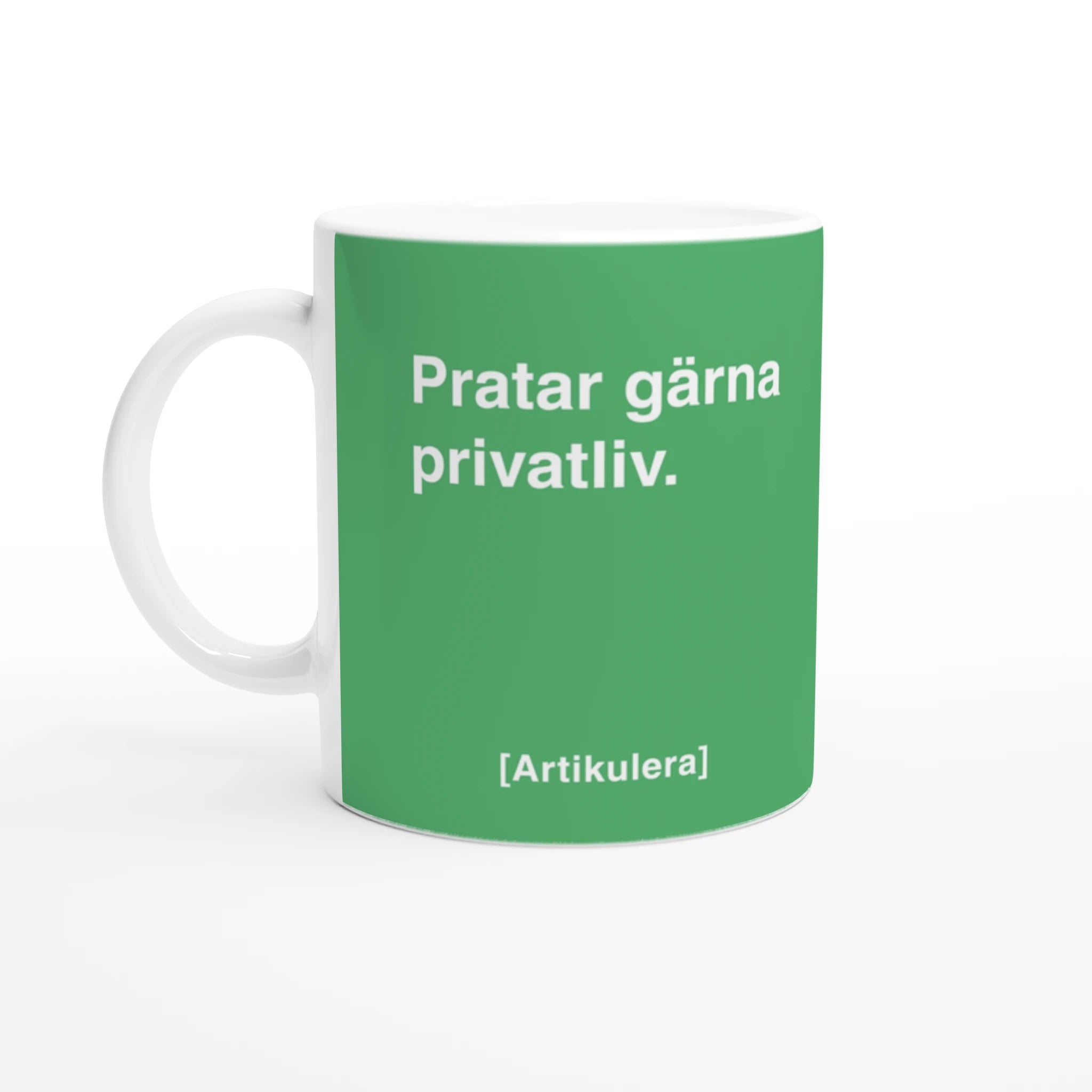 Vit mugg med grönt tryck, vit text ”Pratar gärna privatliv.” samt vit Artikulera-logotyp
