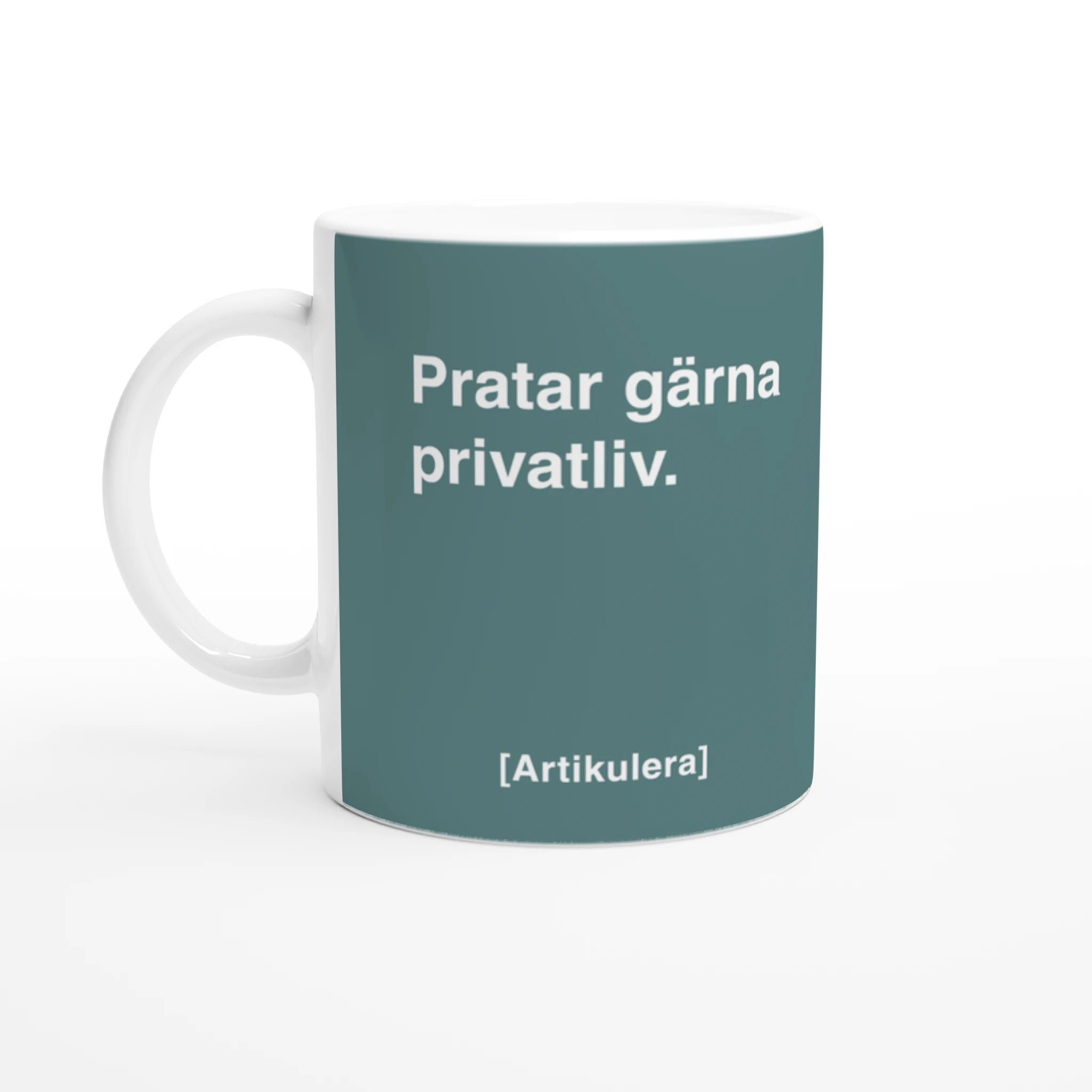 Vit mugg med mörkt turkosgrönt tryck, vit text ”Pratar gärna privatliv.” samt vit Artikulera-logotyp
