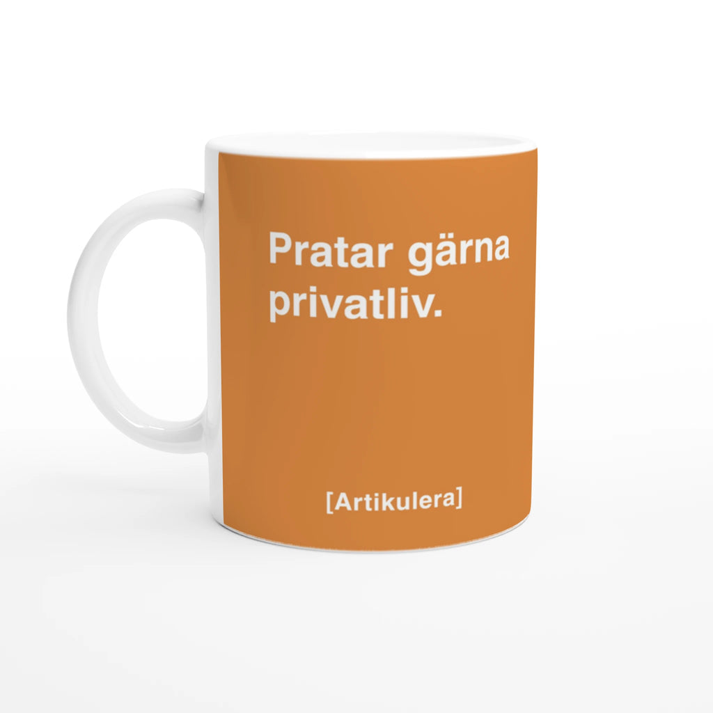 Vit mugg med orange tryck, vit text ”Pratar gärna privatliv.” samt vit Artikulera-logotyp