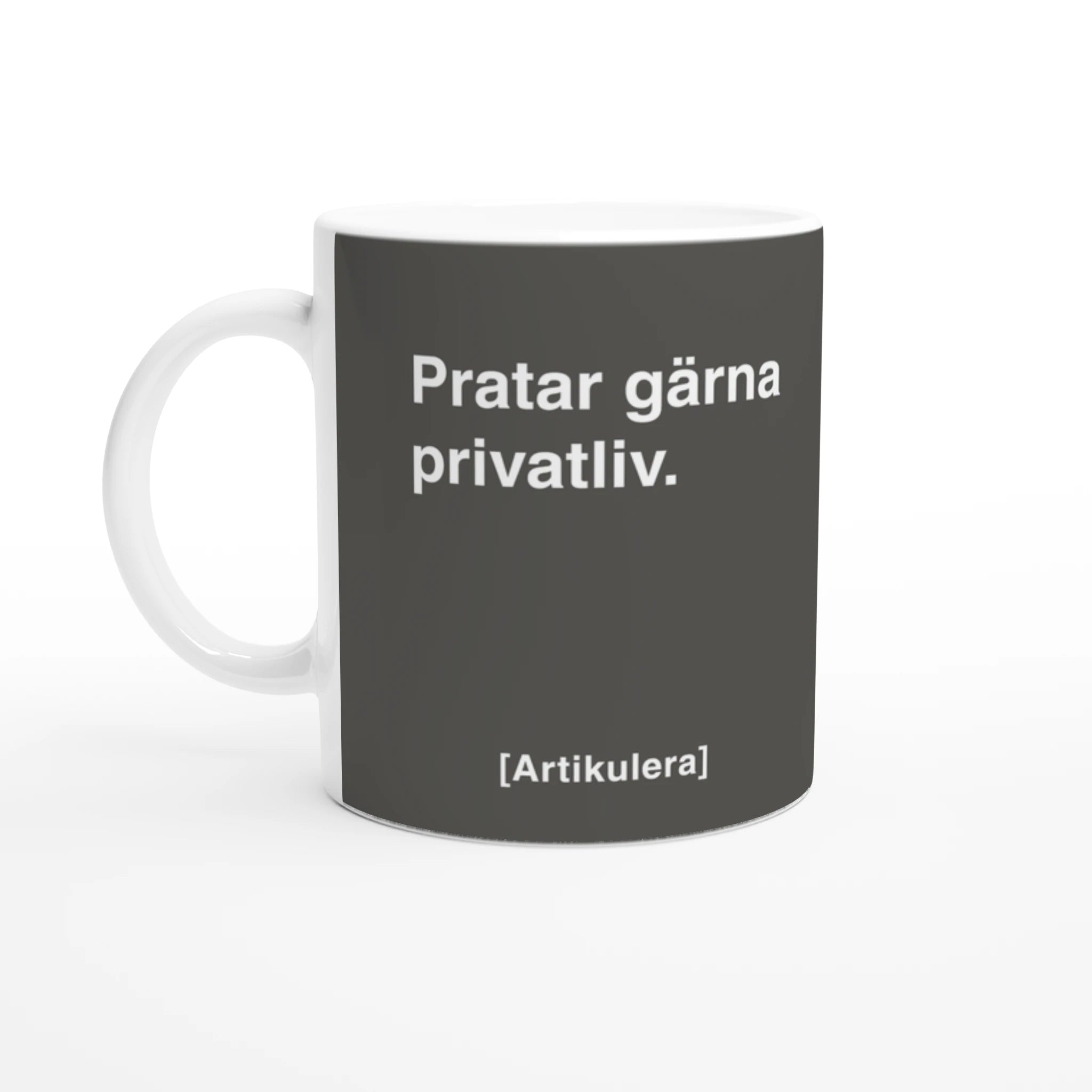 Vit mugg med rockigt grått tryck, vit text ”Pratar gärna privatliv.” samt vit Artikulera-logotyp