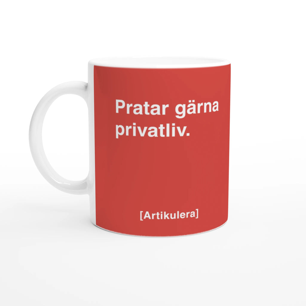 Vit mugg med tomatrött tryck, vit text ”Pratar gärna privatliv.” samt vit Artikulera-logotyp